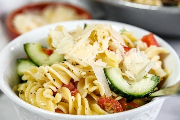 closeup of Italian pasta salad in a bowl topped with parmesan cheese