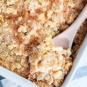 chicken casserole in a white baking dish with a spoonful being scooped out