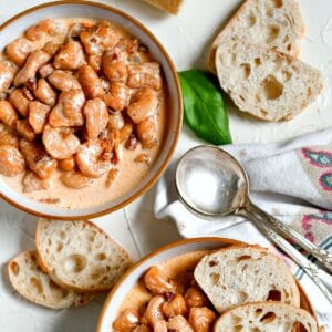 Sweet Potato Gnocchi in bowls with bread slices and two spoons