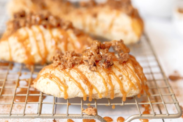 three apples scones on a metal cooling rack topped with cinnamon sugar crumb topping