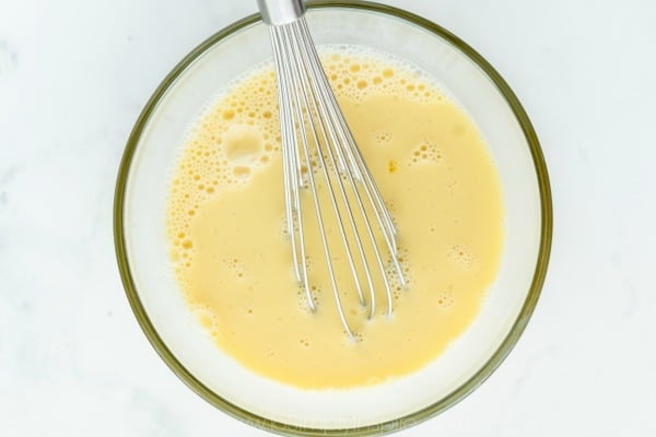 Eggs being whisked in a glass bowl