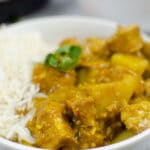 closeup of Chicken curry over rice in a white bowl