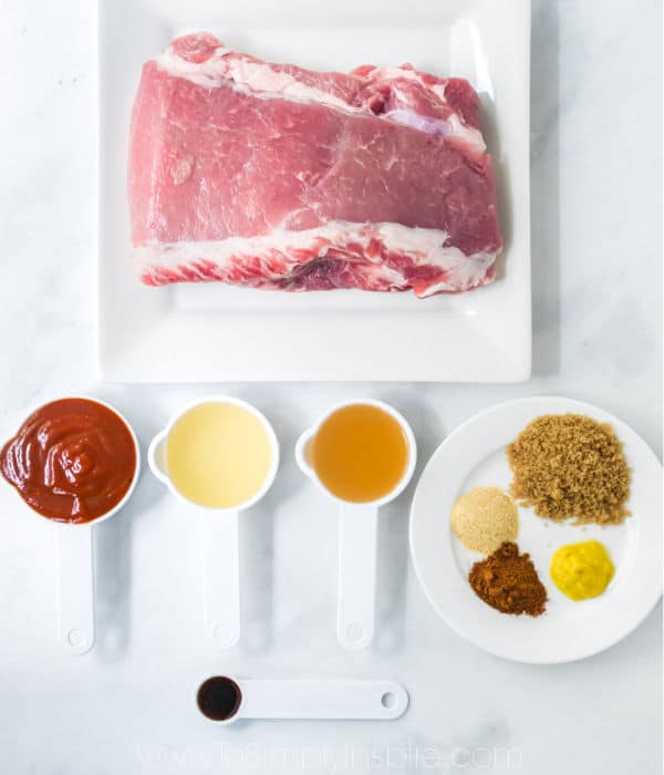 uncooked pork shoulder and white measuring cups with ingredients