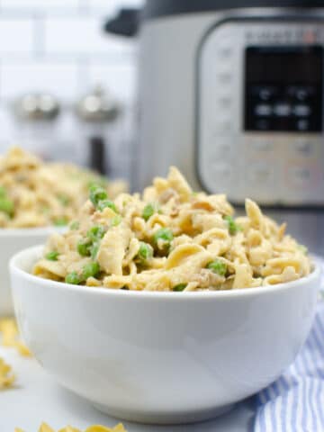 closeup of tuna casserole in a white bowl with instant pot in background