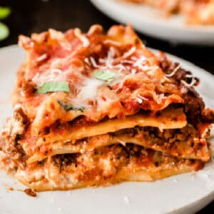 closeup of a slice of lasagna on a white plate