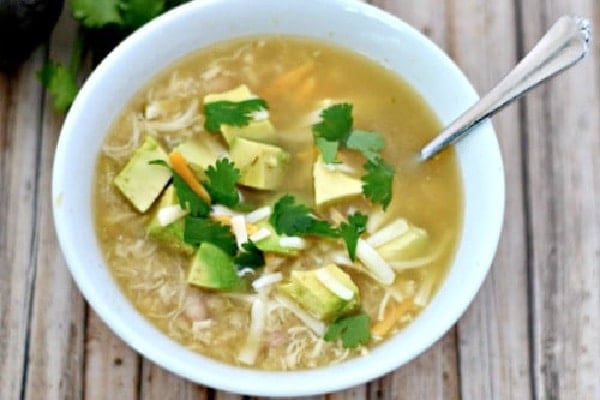 white chicken chili in a bowl with a spoon and topped with cilantro