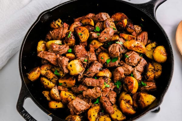 steak bites and potatoes in a cast iron pan