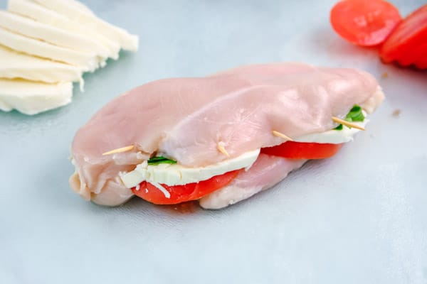 raw chicken breast on a glass cutting board