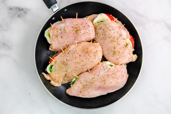 four chicken breasts in a black skillet