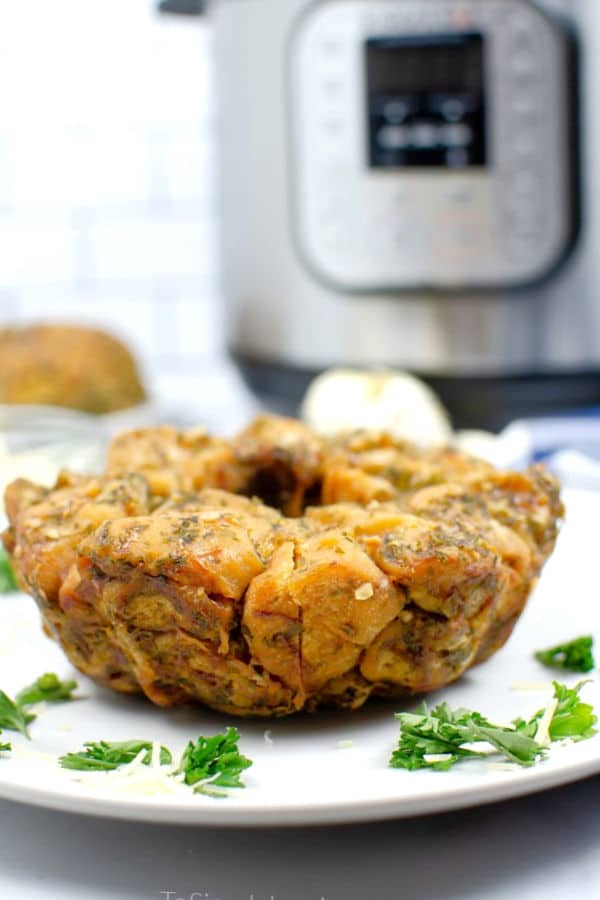 Monkey bread on a white plate with an instant pot in the background