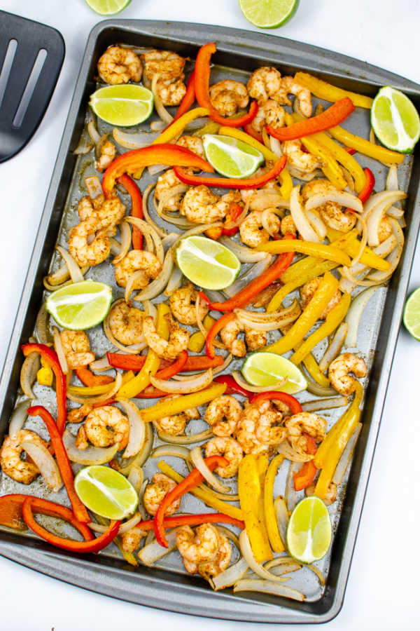 sheet pan shrimp fajitas on a baking sheet topped 