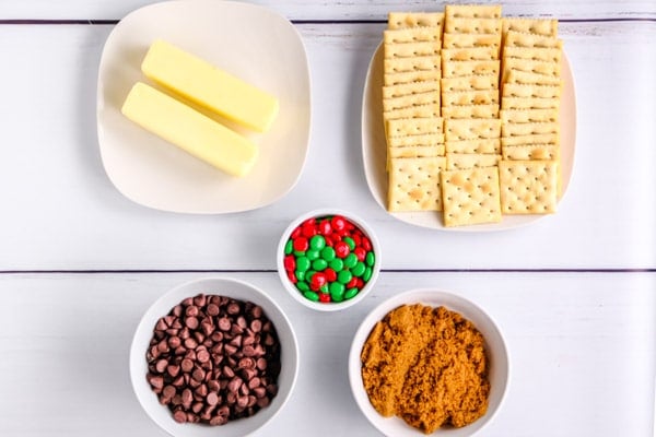 ingredients for Christmas crack and a table: saltine crackers, butter, brown sugar, chocolate chips