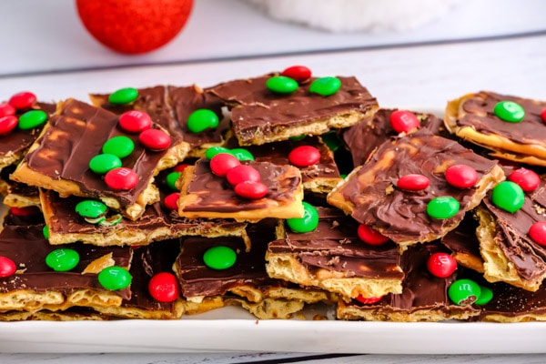 a white rectangle plate full of christmas crack saltine toffee