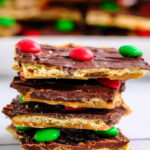 a stack of christmas crack toffee with a plateful in the background