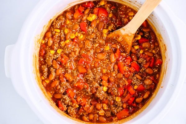 ingredients for mexican casserole mixed into a white crockpot