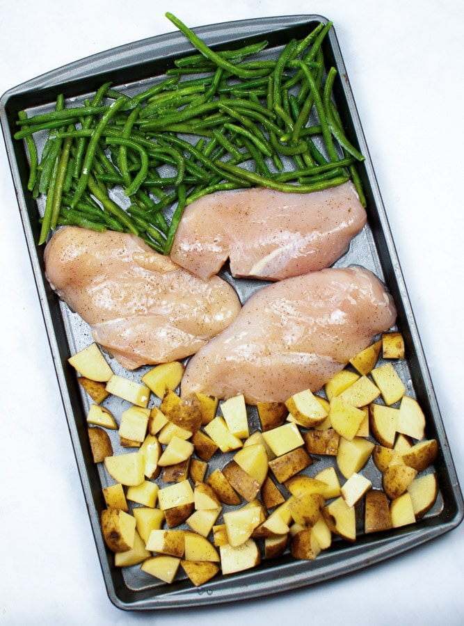 sheet pan with 3 chicken breasts, diced potatoes and green beans