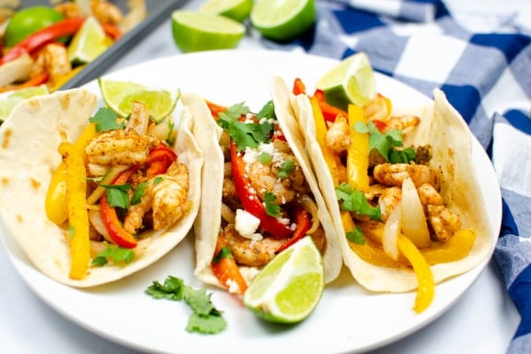 three shrimp fajitas with peppers and onions