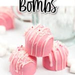 pink hot cocoa bombs stacked on a white table