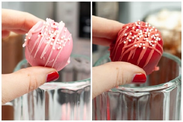 red and pink hot chocolate bombs being put in a glass mug