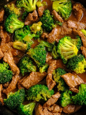 beef and broccoli in a cast iron skillet