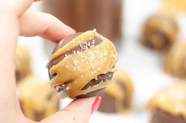 ladies hand holding a salted caramel hot cocoa bomb