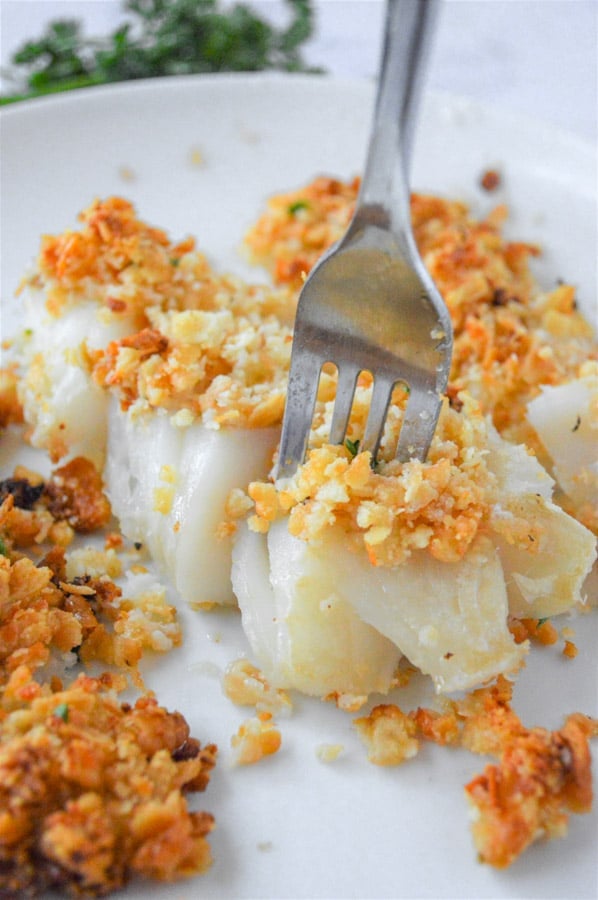 closeup of a crispy baked cod fillet with a fork