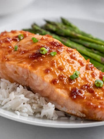 salmon fillet with maple soy glaze on a bed of white rice with asparagus on the side