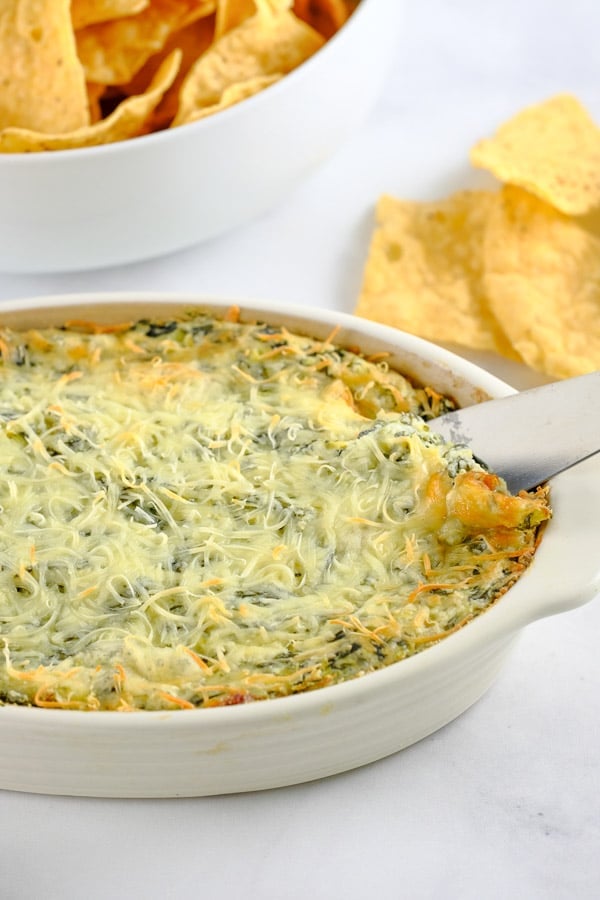 spinach artichoke dip with a bowl of tortilalchips