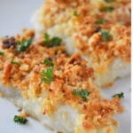 baked cod topped with crispy cracker topping on a white plate