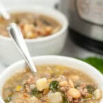 a white bowl with white beans, spinach and sausage soup