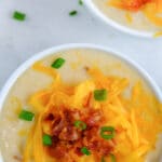 baked potato soup in a white bowl topped with cheese and bacon