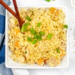 overhead of chicken fried rice in a white bowl with chop sticks