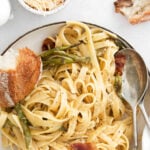 bowl of linguine noodles with asparagus and bacon pieces