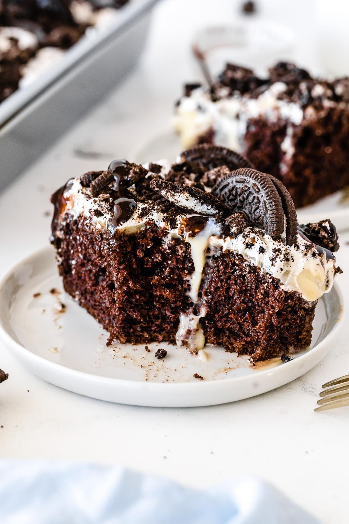 piece of chocolate cake topped with whipped topping and oreo cookie crumbles