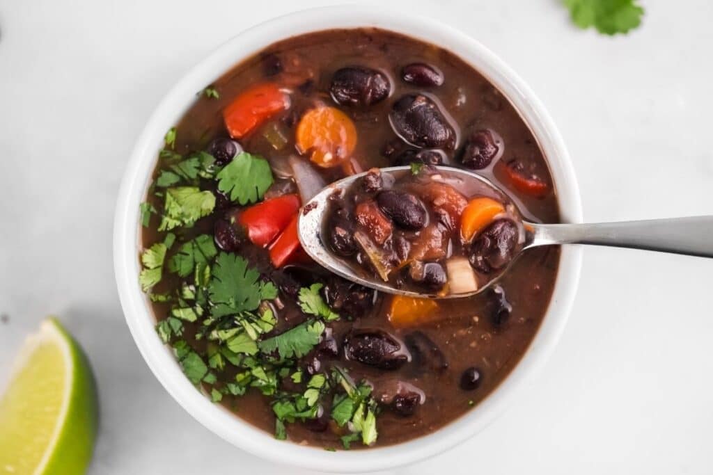 a spoonful of black bean soup over a bowl of soup
