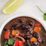 black bean soup in a white bowl with cilantro