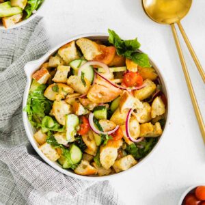 panzanella salad with arugula, bread cubes, tomatoes, red onions and cucumbers