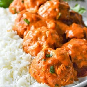 closeup of tikka masala meatballs over white rice