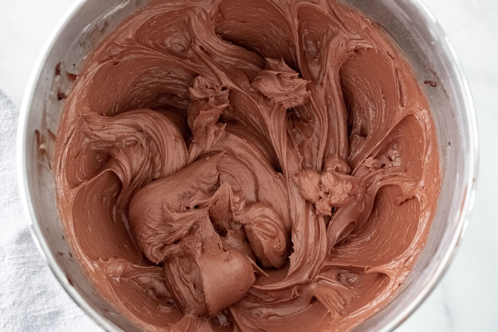 fluffy chocolate frosting in a silver mixing bowl