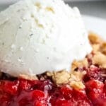 closeup of strawberry crumble with vanilla ice cream on top