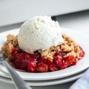 closeup of strawberry crumble with a scoop of vanilla ice cream