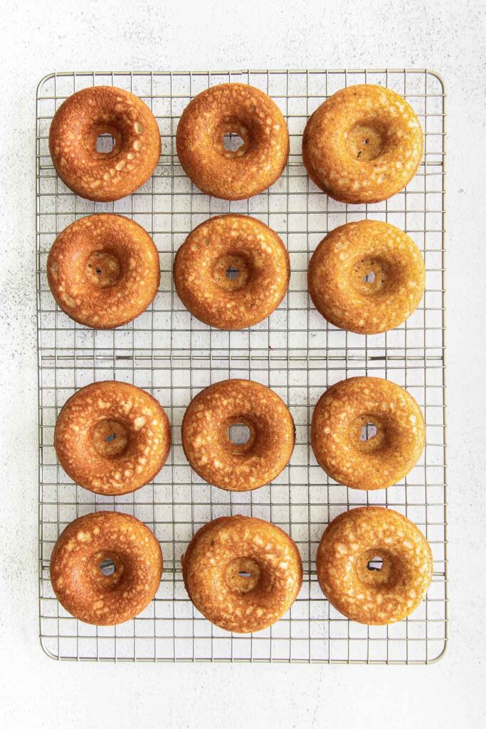 twelve baked donuts on a wire rack