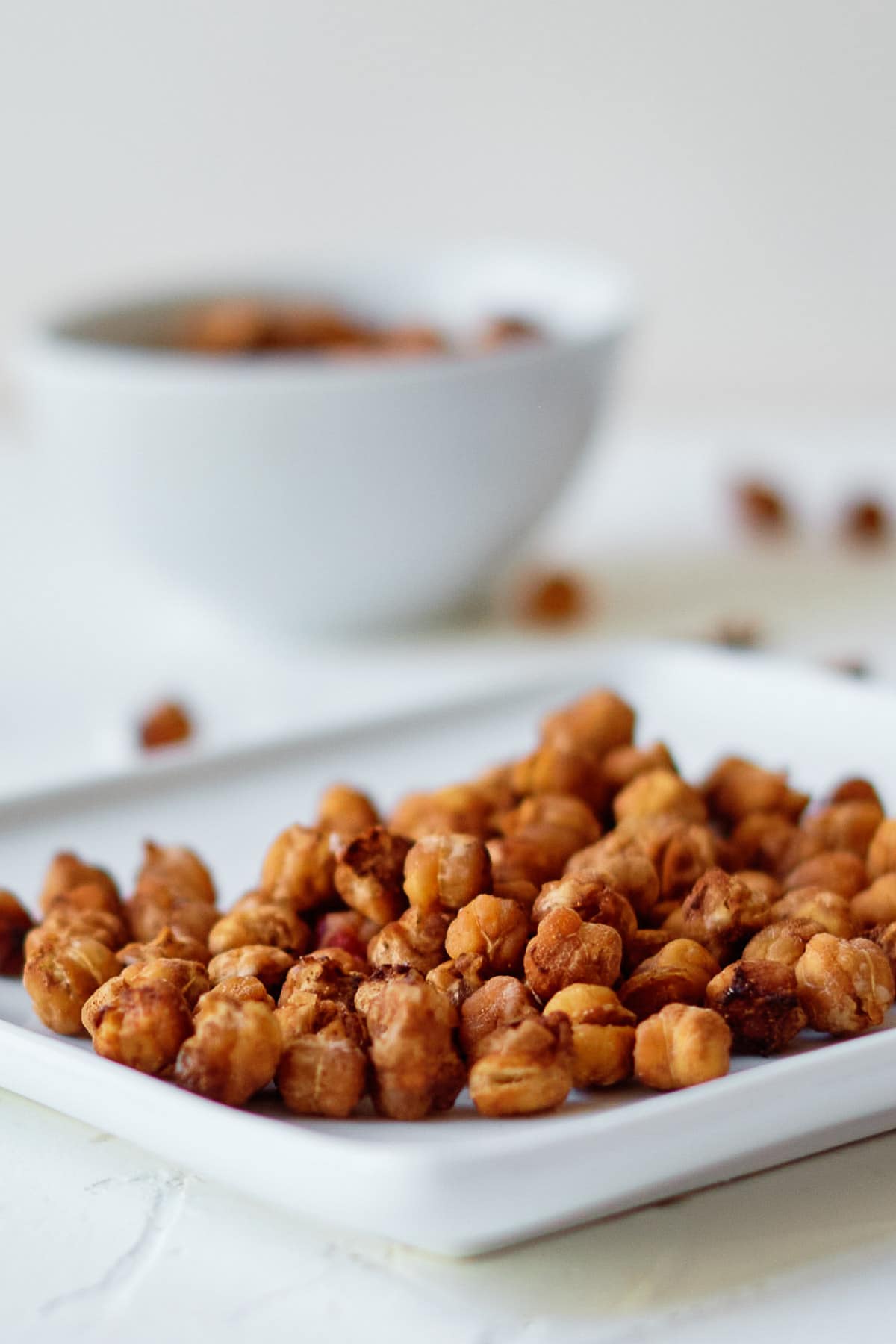 a white plate with roasted chickpeas