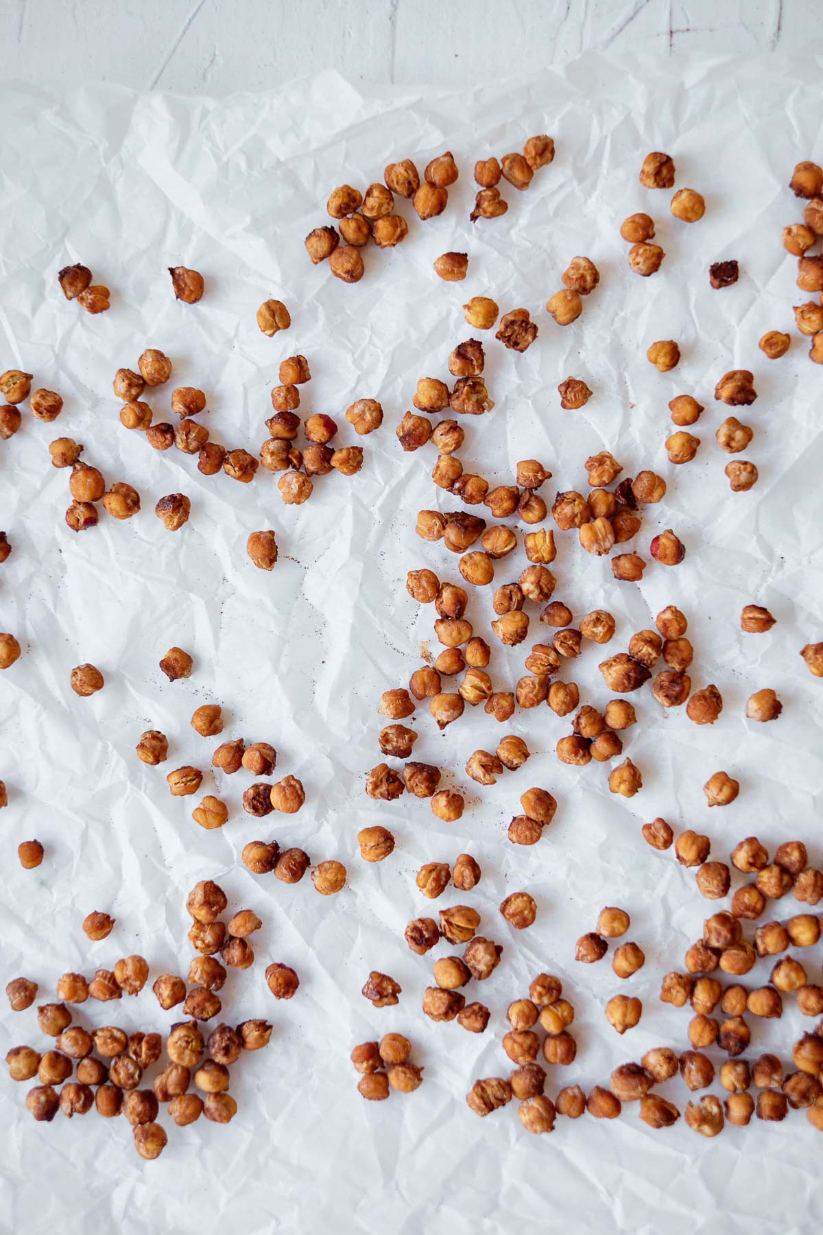 roasted chickpeas spread out on white parchment paper