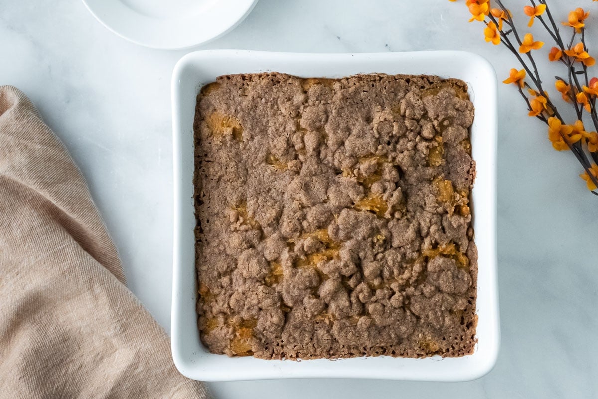 square white baking pan with pumpkin coffee cake with streusel crumb topping