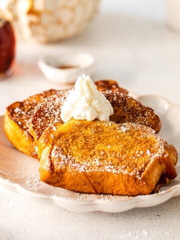 three slices of french toast topped with butter on a white plate