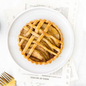 closeup of an apple tart with lattice topping on a white plate