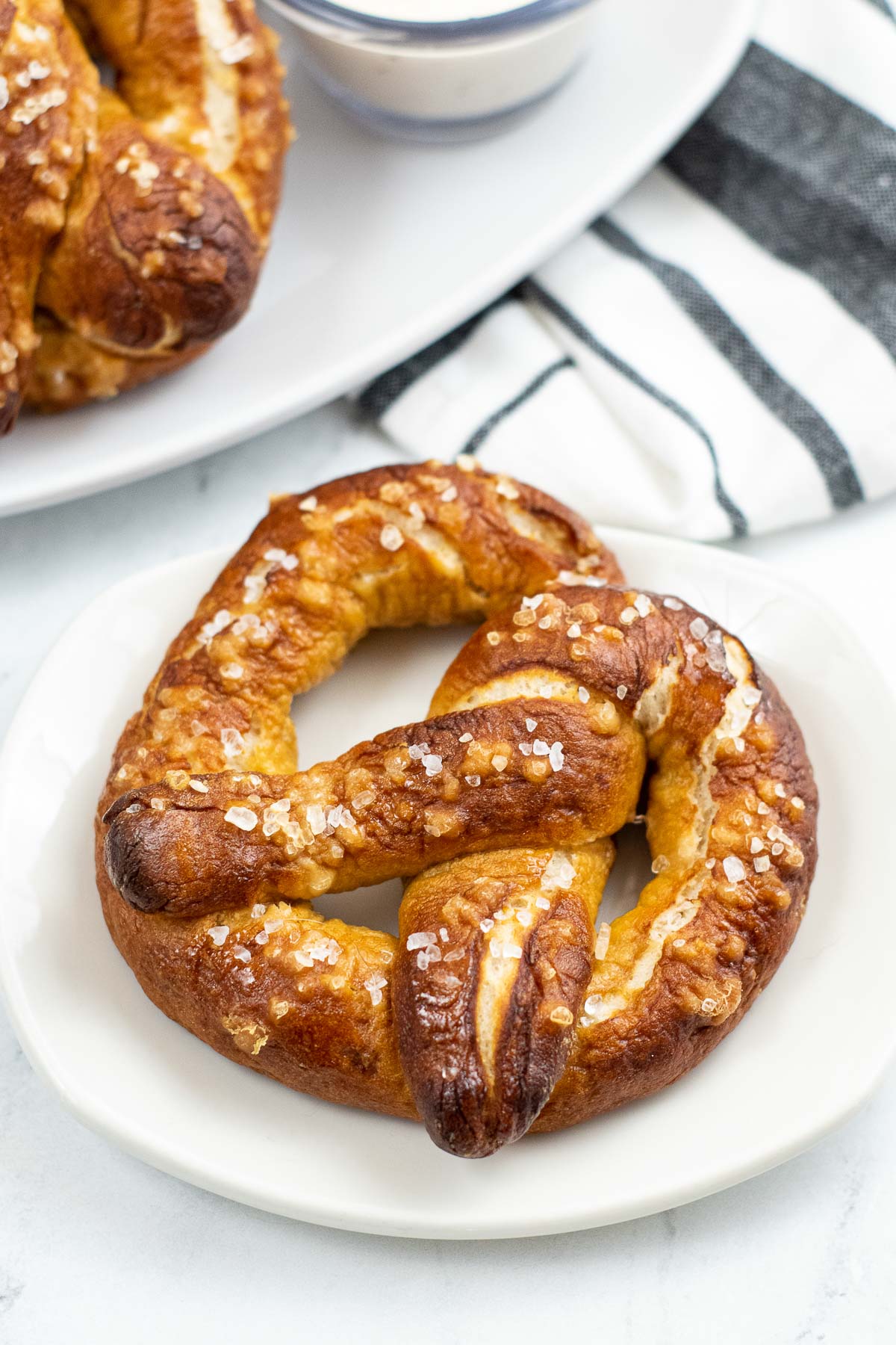 white plate with a big homemade soft pretzel with salt