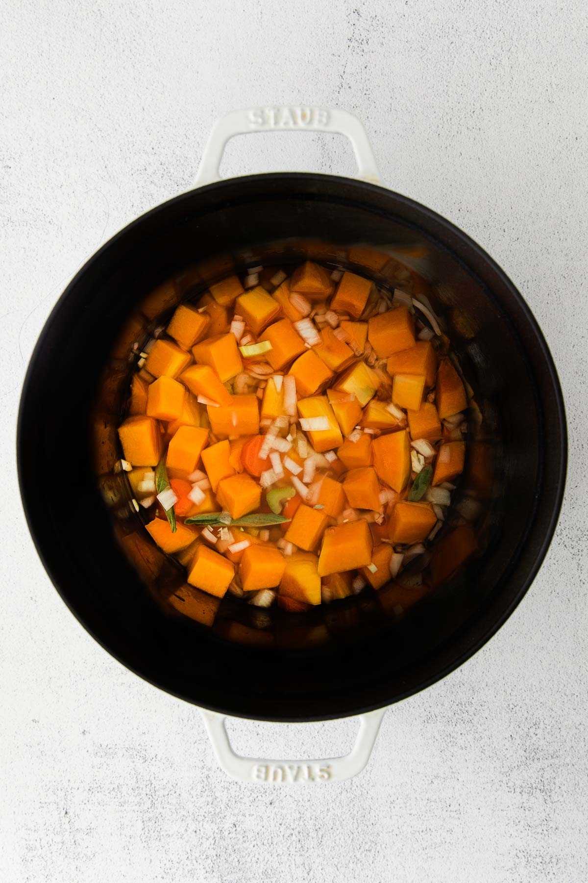 diced butternut squash and chicken broth in a dutch oven