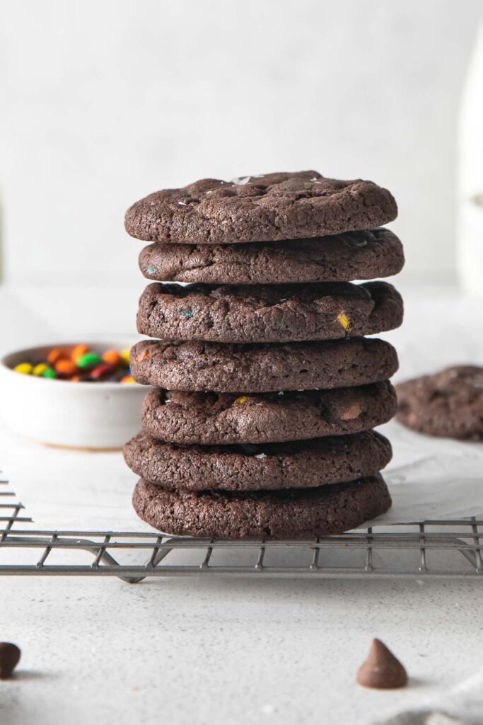 stack of seven chocolate cookies on a wire cooling rack